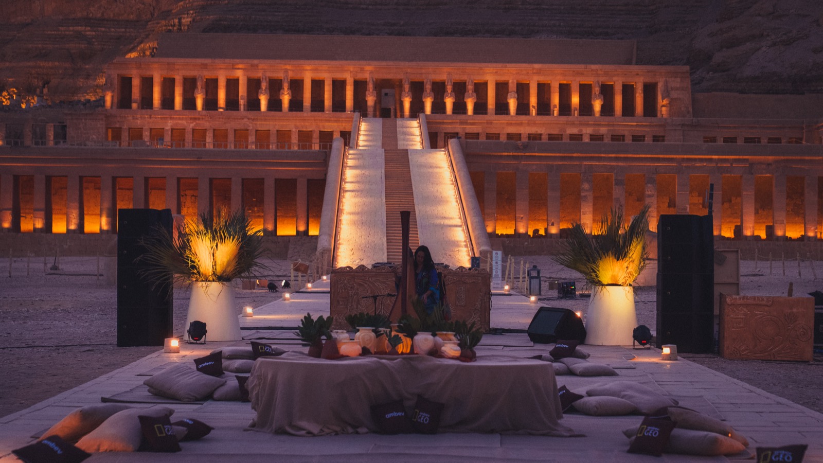 Candle-lit concert stage before the illuminated Temple of Hatshepsut — destination event production